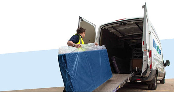 A Medequip van being loaded with a blue mattress by a Medequip staff member.