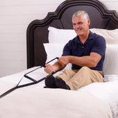 Stander Bed Caddie strap handle used by a man to sit up in bed, in use.