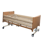Sidhil Bradshaw Mesh Cradle profiling bed with bumpers, side rails and wheels on white background, front angle view.
