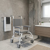 Prism Medical Freeway T90 Paediatric Shower Chair with armrests and antimicrobial coating in a bathroom, front view.