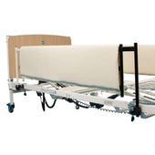 Hospital bed with Sidhil General Side Rail Pads, wooden headboard, wheels and electronic controls under frame, side view.