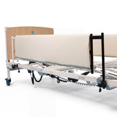 Hospital bed with Sidhil General Side Rail Pads, wooden headboard, wheels and electronic controls under frame, side view.