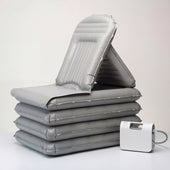 Mangar Camel Lifting Cushion next to an electric air pump on a plain surface, front view.
