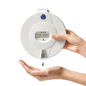 Hand taking a pill from Pivotell Advance Automatic Pill Dispenser with digital display, in use.