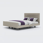 Signature Comfort Dual Profiling Bed with tufted headboard, wheels, white bedding and purple accents, front view.