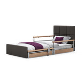 Profiling floor bed with side rails, dark headboard, and purple and white bedding, front view.
