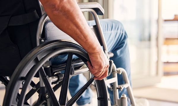 Close-up of a man sitting in a wheelchair at home