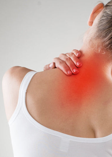 A woman touches her neck with one hand, showing discomfort. Her neck area is highlighted in red against a gray background. Image