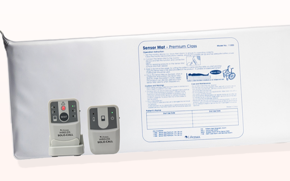 A white sensor mat with instructions, two devices labeled ‚ÄúWireless Solo Call‚Äù with buttons and indicators next to it.