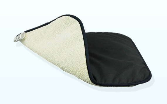 A black and beige reversible mat is shown, with one corner folded to display both sides. The black side is smooth, while the beige side appears to be textured, possibly for cleaning or wiping.