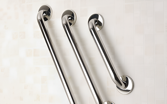 Three stainless steel grab bars of varying lengths are securely mounted on a light-colored tiled wall, arranged diagonally and parallel to each other.