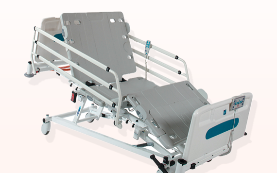 A person is lying in a hospital bed with adjustable parts for the head and legs, featuring side rails and wheels for easy mobility.