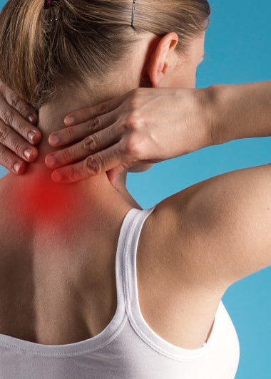 A woman in a white tank top faces away, holding her neck. Red marks on her neck suggest pain. The background is light blue. Image