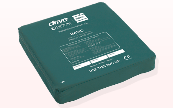 A green pressure care cushion with use instructions, safety icons, and USE THIS WAY UP marked on the underside.