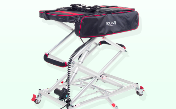 A portable grooming table with black and red padded top, aluminum frame, wheels for movement, and a cord control for height adjustment.
