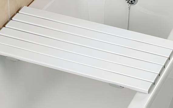 A white bath board spans a tub, offering a secure sitting surface with grips and grooves for safety and convenience.