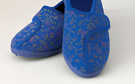 Floral shoes featuring pink, yellow, and purple flowers with Velcro strap on a white background.