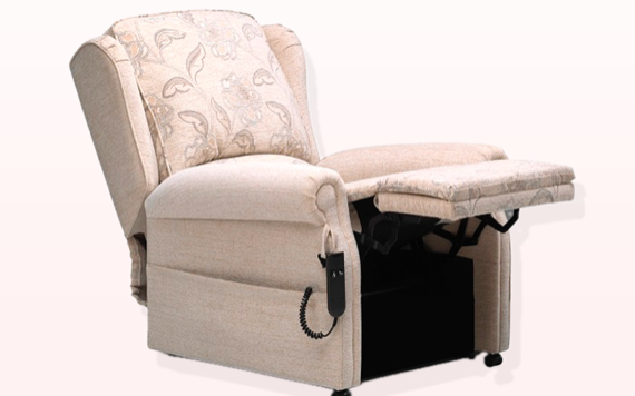 A comfortable beige recliner with a floral design, extended footrest, side control panel, and power cord on a simple light backdrop.