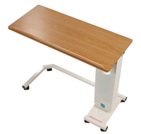 Sidhil Easi-Riser overbed table with woodgrain top, white metal frame, height-adjustable and wheeled base, wheelchair access, front view.