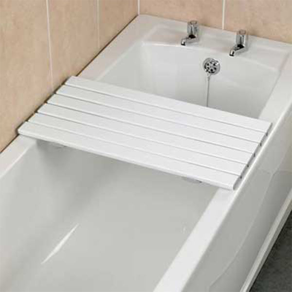 Savanah slatted shower board placed over a bathtub next to a tiled wall and two taps, in use view.
