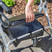 NRS 2 in 1 Rollator and Transit Chair with padded seat lifted to show under-seat fabric storage, outdoor setting, close-up.