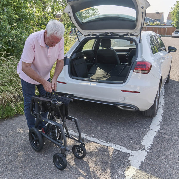 Nitron Powerchair folded next to a car