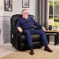 Man sitting in a Motion Healthcare Alberta Bariatric Dual Motor Riser Recliner Chair in a bright living room, in use view.