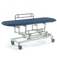 Dark blue electric changing table with height-adjustable frame, side rails and wheels, front angled view.