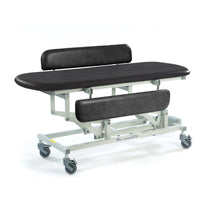 Black height adjustable changing table with padded backrest, side rail and wheeled metal frame, side view.