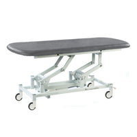 Dark grey electric therapy hygiene table with padded top, white wheeled frame, height adjustable, clinic equipment, side view.