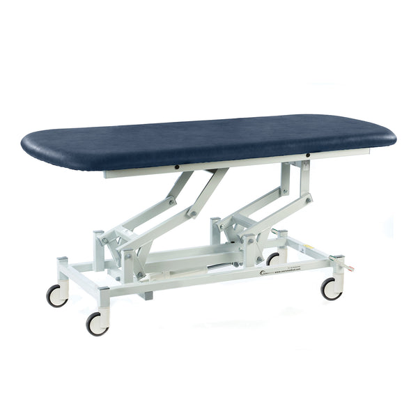 Dark blue SEERS Medical hydraulic therapy hygiene table with padded top and adjustable height, side view.
