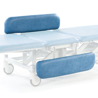 Sky blue hydraulic therapy hygiene table with cushioned supports, adjustable sections, and white wheels, side view.