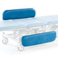 Hydraulic therapy hygiene table with blue supports, light blue cushion and white wheeled frame, side view.
