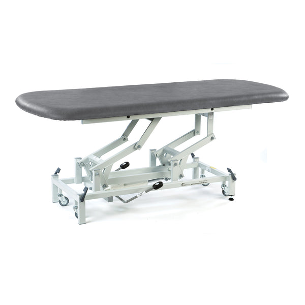 Dark grey SEERS Medical electric therapy hygiene table with padded top, metal frame, wheels, adjustable height, side view.