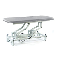 Light grey SEERS Medical electric therapy hygiene table, padded and height adjustable, suitable for clinical use, side view.