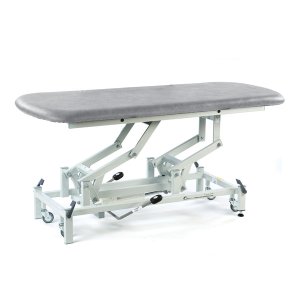 Light grey SEERS Medical electric therapy hygiene table, padded and height adjustable, suitable for clinical use, side view.