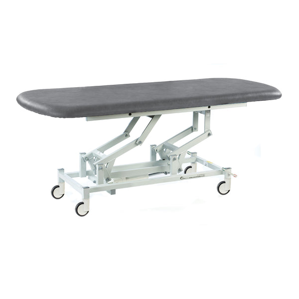 Dark grey electric therapy hygiene table with height adjustment, padded top and wheels, side view.