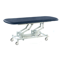 Dark blue SEERS Medical hydraulic therapy hygiene table with height adjustment, white frame and castors, side view.