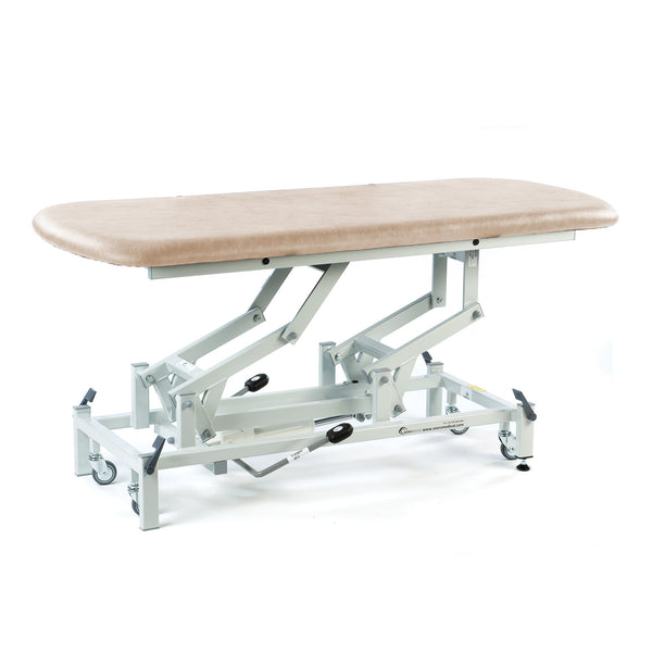 Cream hydraulic therapy hygiene table with height adjustment and wheels, shown in a side view.