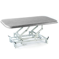 SEERS Medical Electric Therapy Mat Table with padded surface and metal wheeled frame, side view.