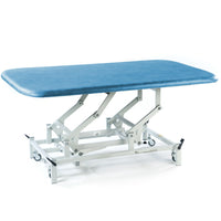 SEERS Medical electric therapy mat table with padded top, adjustable height, white metal frame and wheeled legs, side view.