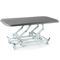 SEERS Medical Electric Therapy Mat Table with height-adjustable padded surface and wheeled frame, side view.