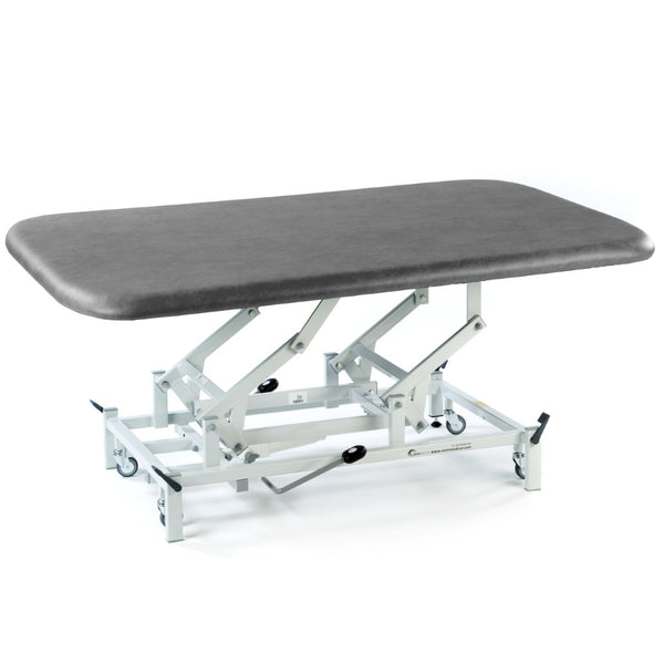 Hydraulic therapy mat table in dark grey with height adjustment and white wheeled frame, side view.