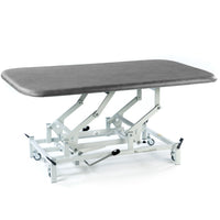 Dark grey hydraulic therapy mat table with white wheeled frame and height adjustment, side view.