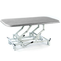 SEERS Medical Hydraulic Therapy Mat Table with height-adjustable top and white wheeled frame, side view.