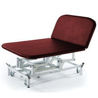 Burgundy electric Bobath therapy couch with white wheeled frame, suitable for physiotherapy, side view.
