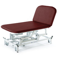 Burgundy SEERS Medical electric Bobath couch with white frame and wheels, shown from the side.