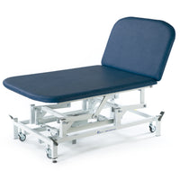 Dark blue SEERS Medical electric Bobath couch with adjustable backrest and white metal wheeled frame, side view.