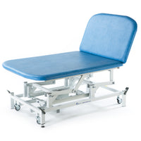 Sky blue electric therapy Bobath couch with adjustable backrest and white wheeled frame, side view.