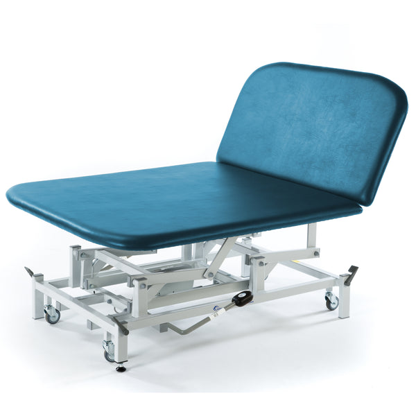 Hydraulic Bobath therapy couch with teal upholstery, raised backrest and wheeled base, side view.